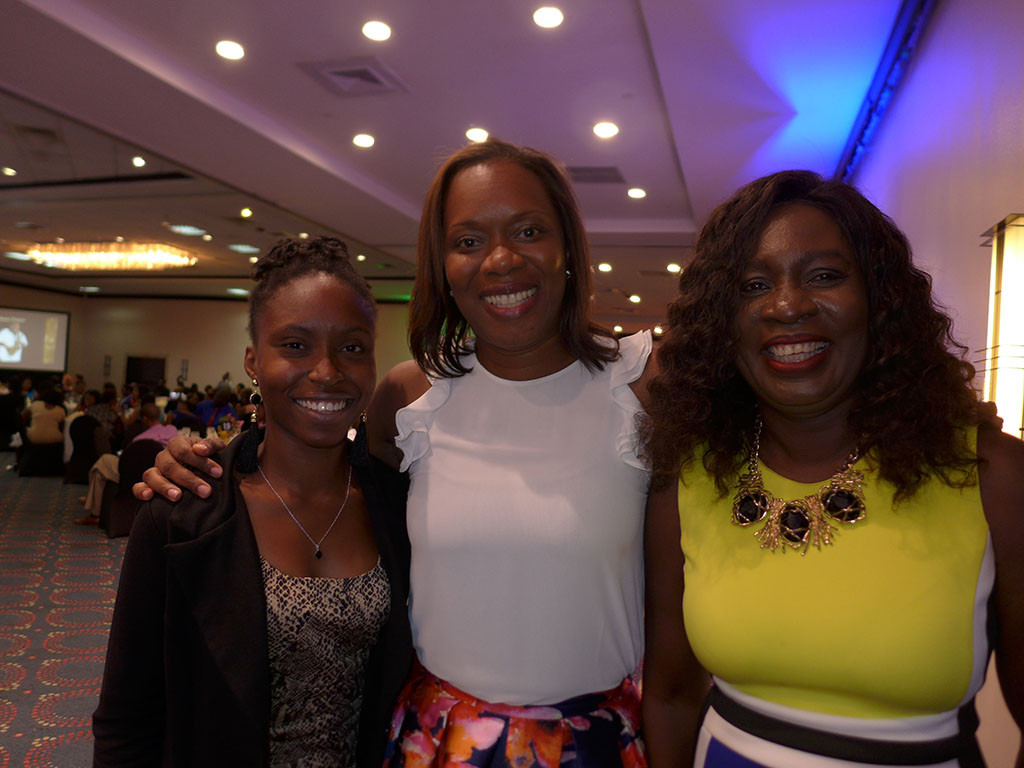 Sineal Smith (from left), a second year student in the Faculty of Law, at The University of the West Indies, Mona, share a hug with Alphie Mullings-Aiken, president, JAJ, and Delories Jones, senior vice president, sales and business development, JN Fund Managers.